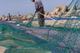 Image du Maroc Professionnelle de  Des ouvriers s'activent à réparer leurs filets de pêches au port de Laayoune, située à quelque kilomètre de la ville de Laayoune capitale du Sahara marocain, Vendredi 21 Septembre 2001. (Photo / Abdeljalil Bounhar) 